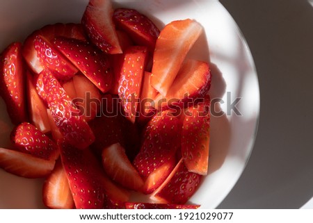Close-up of carved strawberries in a white porcelain bowl.