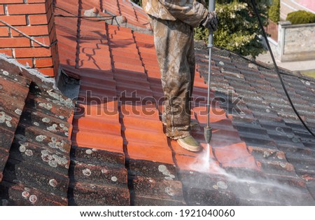 State of roof before and after washing with high pressure. Professional is wearing uniform and using equipment for cleaning. Royalty-Free Stock Photo #1921040060