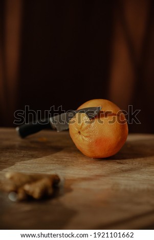 Beautiful fresh fruit carefully placed on a wooden surface while  being cut by a woman and placed on a glass fruit tray