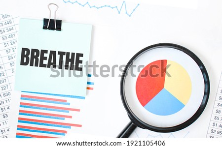 Green card on the white notepad and magnifier on the financial documentation. Text breathe. Business concept