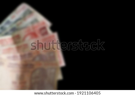 Money blurred unfocused on black background.