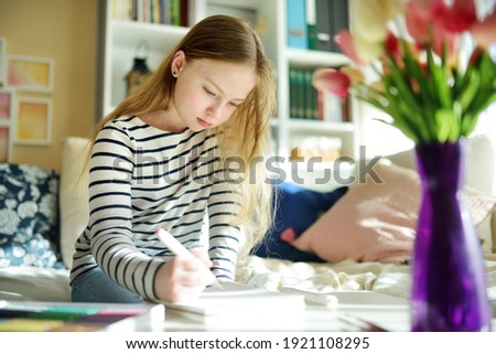 Cute young girl writing letter at home. Child doing her homework in her room. Education for kids