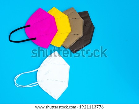 Colored reusable masks on blue background. Copy space