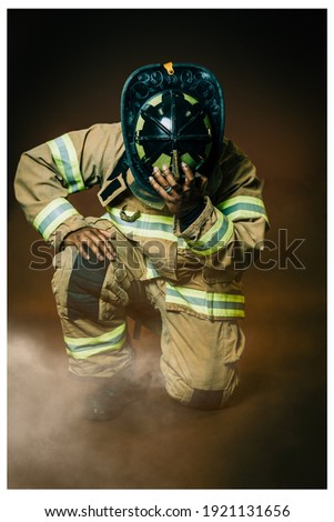 A firefighter kneeling after a long day