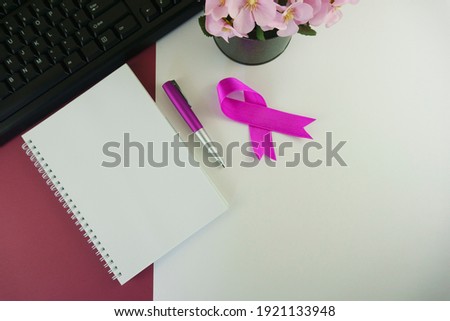 Computer Keyboard, Noted Pad, Pen, Flowers on Multi Colored Background.