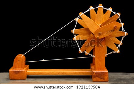 India's famous spinning wheel called charkha of mahatma gandhi on black background selective focus Royalty-Free Stock Photo #1921139504