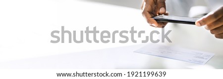 Remote Check Deposit Taking Photo With Mobile Phone Royalty-Free Stock Photo #1921199639