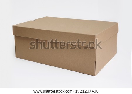 Brown cardboard shoes box with lid for shoe or sneaker product packaging mockup, isolated on white background with clipping path. Craft paper box. Front view.  Royalty-Free Stock Photo #1921207400