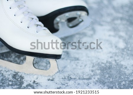 close-up of figure skates on an ice background. Ice skating outdoor activities with the family in winter.