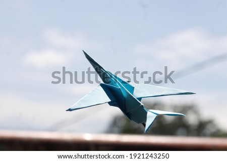 blue airplane. made of paper. origami airplane. an airplane flying in the sky