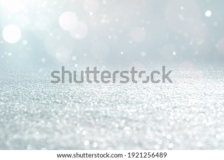 GLITTERING CHRISTMAS BACKGROUND, ICE AND BOKEH LIGHTS WITH SNOW, LIGHT FESTIVE SILVER BACKDROP WITH COLD BRIGHT EFFECT, DESIGN WITH EMPTY SPACE FOR MONTAGE OR DISPLAY PRODUCTS OR CHRISTMAS PRESENTS