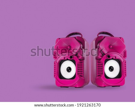 Pink speaker isolated on purple background