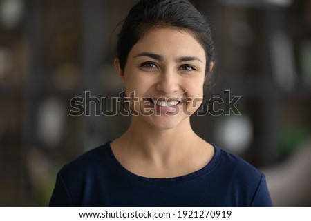Close up headshot portrait of young 20s Indian woman pose look at camera feel optimistic. Profile picture of smiling millennial mixed race female renter or tenant in new own home. Diversity concept.