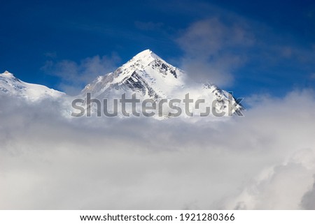 Snowy peak of the Denali mountain (Mt. McKinley) with blue sky and the clouds around.  Denali NP, Alaska Royalty-Free Stock Photo #1921280366