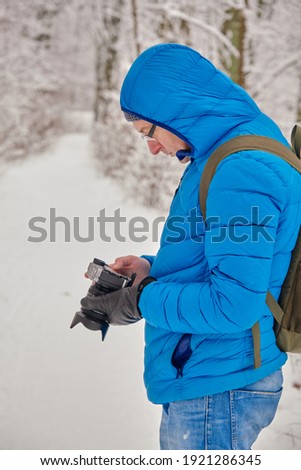 professional cameraman with camera taking shoots in snow forest