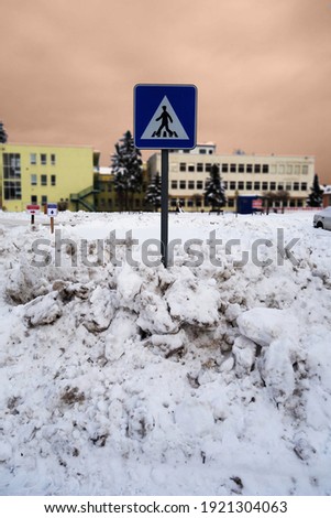 Snowy sidewalk for pedestrians with traffic sign after the massive snowfall