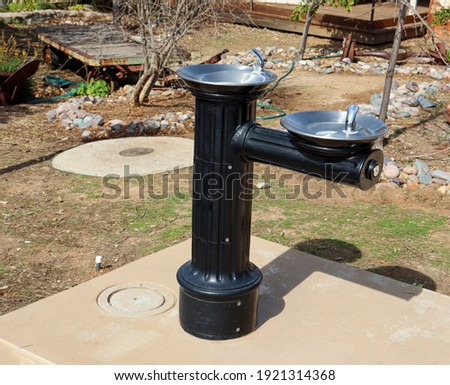 A free standing pedestal hi-low antique style outdoor drinking fountain at a the Old Poway Park and Village in California. 