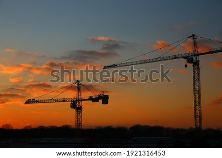 Industrial cranes at a construction site at sunset