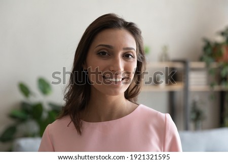 Profile picture of young happy indian female posing by webcam give interview provide distant training webinar. Head shot portrait of pretty millennial arabic woman looking at camera making video call