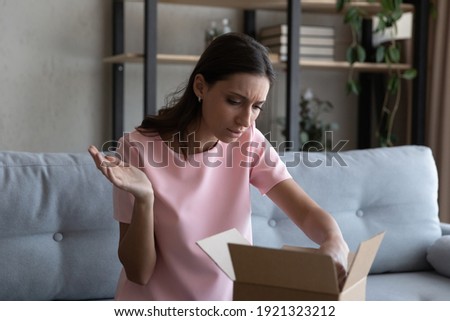 What is the matter. Angry arabian lady courier service customer received damaged broken package container. Frustrated indian woman web shopper get unpack order disappointed with wrong item bad quality Royalty-Free Stock Photo #1921323212
