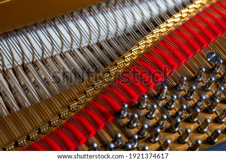 A close-up of the internal string structure of a top grand piano