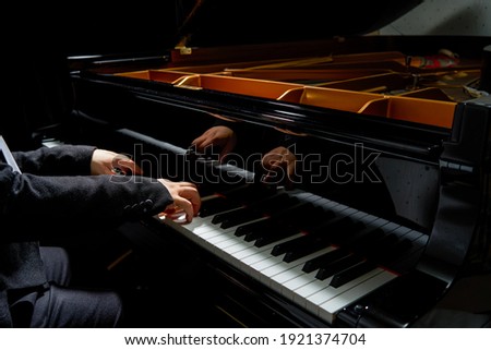 A pianist plays on the grand piano