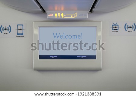 plane interior info screen welcoming passengers