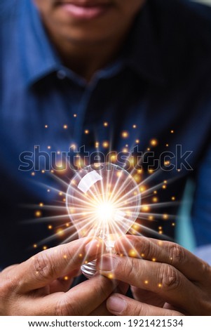 Vertical hand man holding illuminated light bulb, concept creativity with bulbs shine glitter, ideas for sustainable business development innovation and inspiration concept. Royalty-Free Stock Photo #1921421534