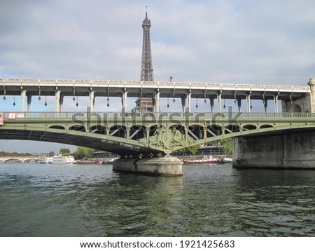 Scenic famous view of the bridge with Eiffel Tower on the river on a cloudy day.                                     