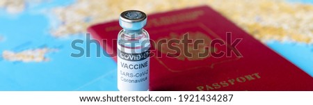 COVID-19, travel and vaccine concept, panoramic banner with bottle of coronavirus vaccine and passport on tourist map. Vaccination due to restrictions, tourism hit by corona virus during pandemic.