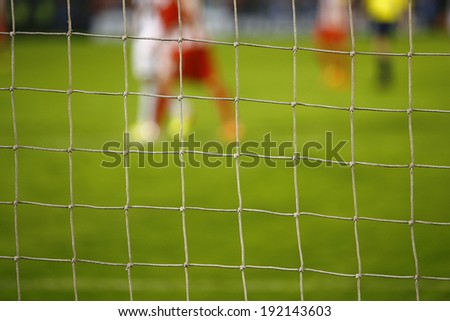 Goal net and blurred soccer players