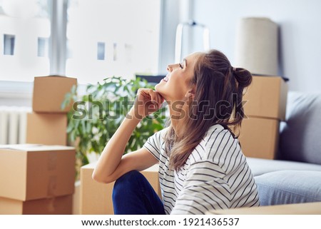Young woman celebrates moving into a new apartment Royalty-Free Stock Photo #1921436537
