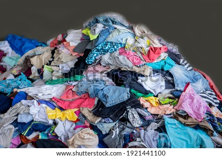 Old clothes, secondhand clothes Garbage from old rags was thrown into a large pile. Royalty-Free Stock Photo #1921441100
