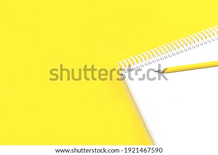 Open notepad on trendy yellow illuminating background. Minimal with copy space for back to school education test and craft or message concept. Storytelling mockup web banner