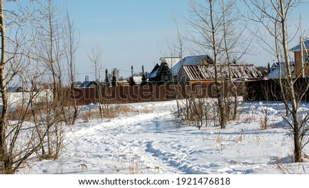 Snow-covered path to village houses. Winter landscape. Countryside