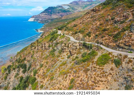 Aerial view of the famous D80 road around Cap Corse peninsula, the important tourist path in Corsica Island. Haute-Corse, France. Tourism and vacations concept
