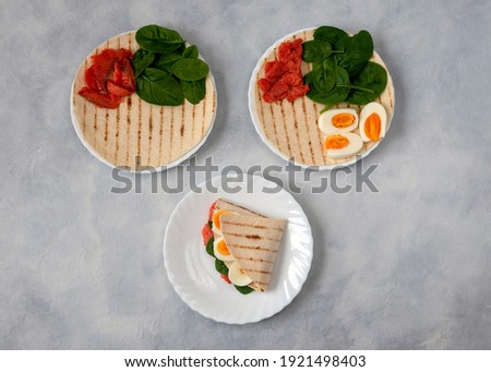 Tortillas with various fillings of lightly salted trout, spinach and boiled eggs for breakfast, lunch or dinner. Food trend. Delicious and healthy snack. Royalty-Free Stock Photo #1921498403
