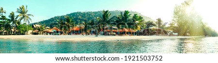 Tropical beach with palm trees and tropical plants and bungalows, tourist vacation Panoramic view of Paradise tropical beach Thailand Banner
