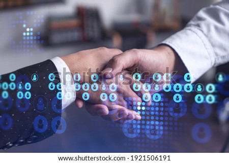 Recruitment concept of hiring of a new talented specialists for international company. Handshake as a concept of agreement to sign an employment contract. Social media hologram icons.