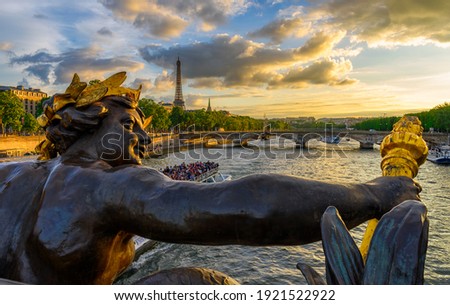 The Nymph reliefs on the bridge of Alexander III with the Eiffel Tower on background at sunset in Paris, France. Architecture and landmarks of Paris. Postcard of Paris