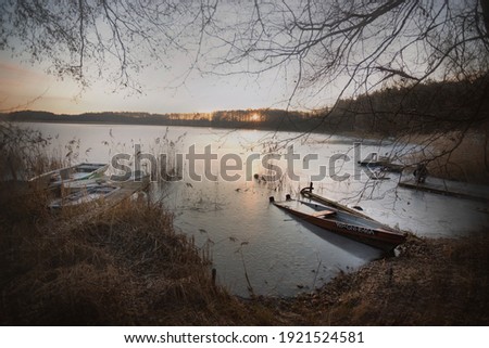 Sunrise at a lake on winter morning, frozen lake, people fishing , resting or taking photos