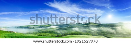 Panorama, Italian beautiful landscape, foggy rolling fields of Tuscany in light of the rising sun Royalty-Free Stock Photo #1921529978
