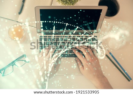 Double exposure of man's hands typing over computer keyboard and DNA hologram drawing. Top view. Medical education concept.