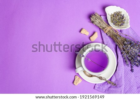 Lavender hot tea on pastel lilac background. Natural flower drink for morning good mood, top view