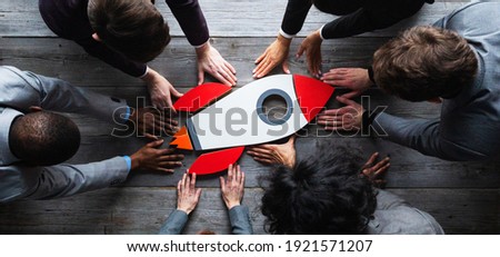 Team of business people with rocket as a sumbol of high risky goals targets success at meeting table Royalty-Free Stock Photo #1921571207
