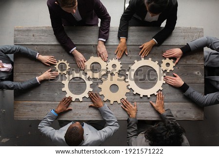 Business people connect golden gear together at meeting table, success cooperation teamwork concept Royalty-Free Stock Photo #1921571222