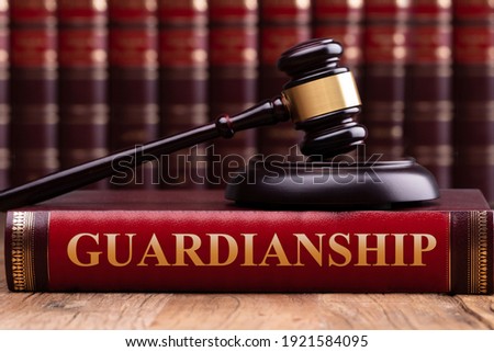 Judge Gavel And Striking Block Over Law Book With Guardianship Law Text On Wooden Desk Royalty-Free Stock Photo #1921584095