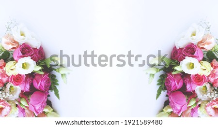 Pink ranunculi and white roses on a white background. A delicate festive composition. Background for greeting cards, invitations.