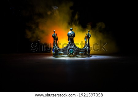 low key image of beautiful crown over wooden table. vintage filtered. fantasy medieval period. Selective focus. Colorful backlight