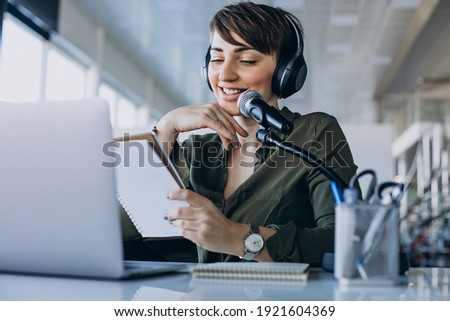 Young woman with microphone recording voice acting